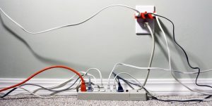 StillLifeofanElectricalWallOutletOverloadedwithPlugsandExtensionCords