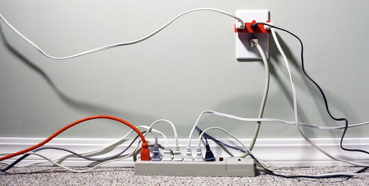 StillLifeofanElectricalWallOutletOverloadedwithPlugsandExtensionCords