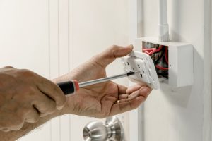 Close view of a male electrician's hands as he installs a new outlet.